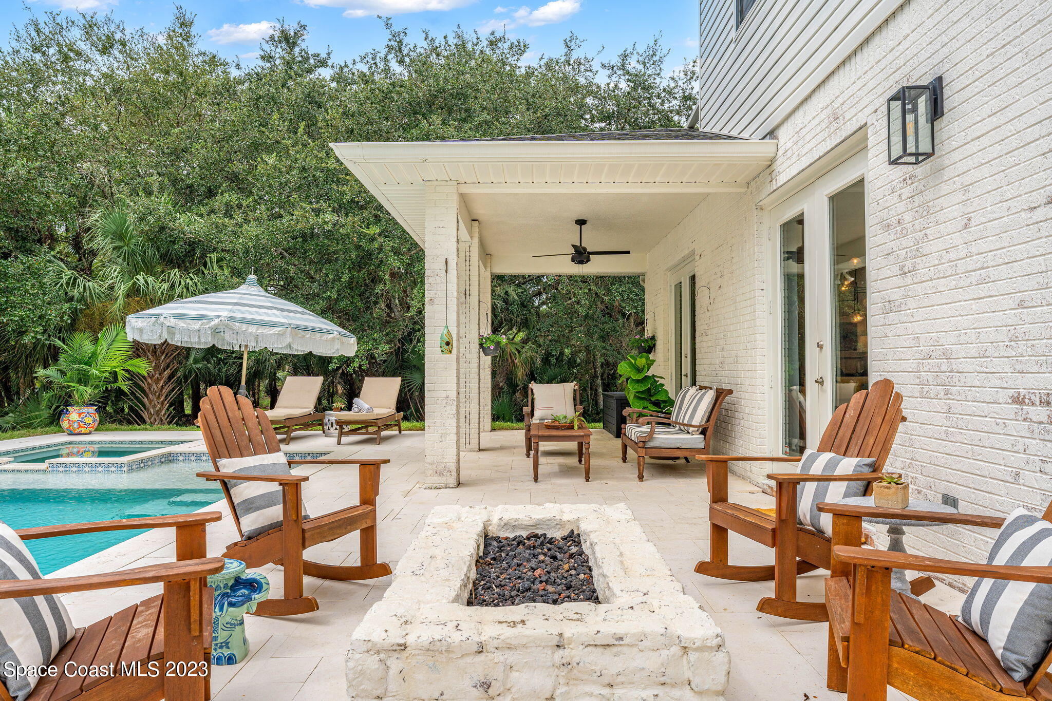 5595 Willoughby Drive Melbourne, FL 32934 - Photo 22 of 40 a view of a patio with a table and chairs under an umbrella