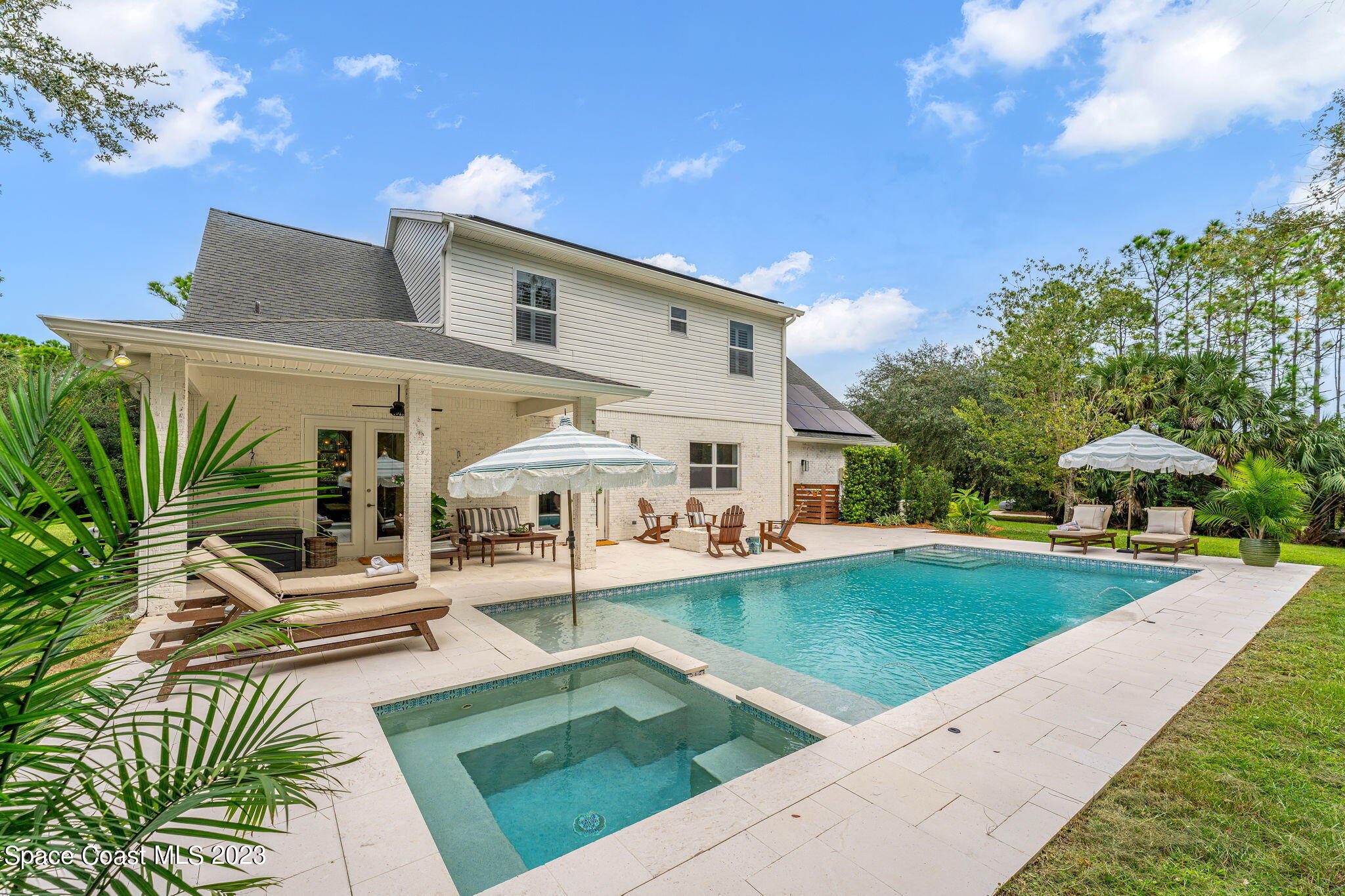 5595 Willoughby Drive Melbourne, FL 32934 - Photo 23 of 40 a view of a white house with a yard patio and swimming pool