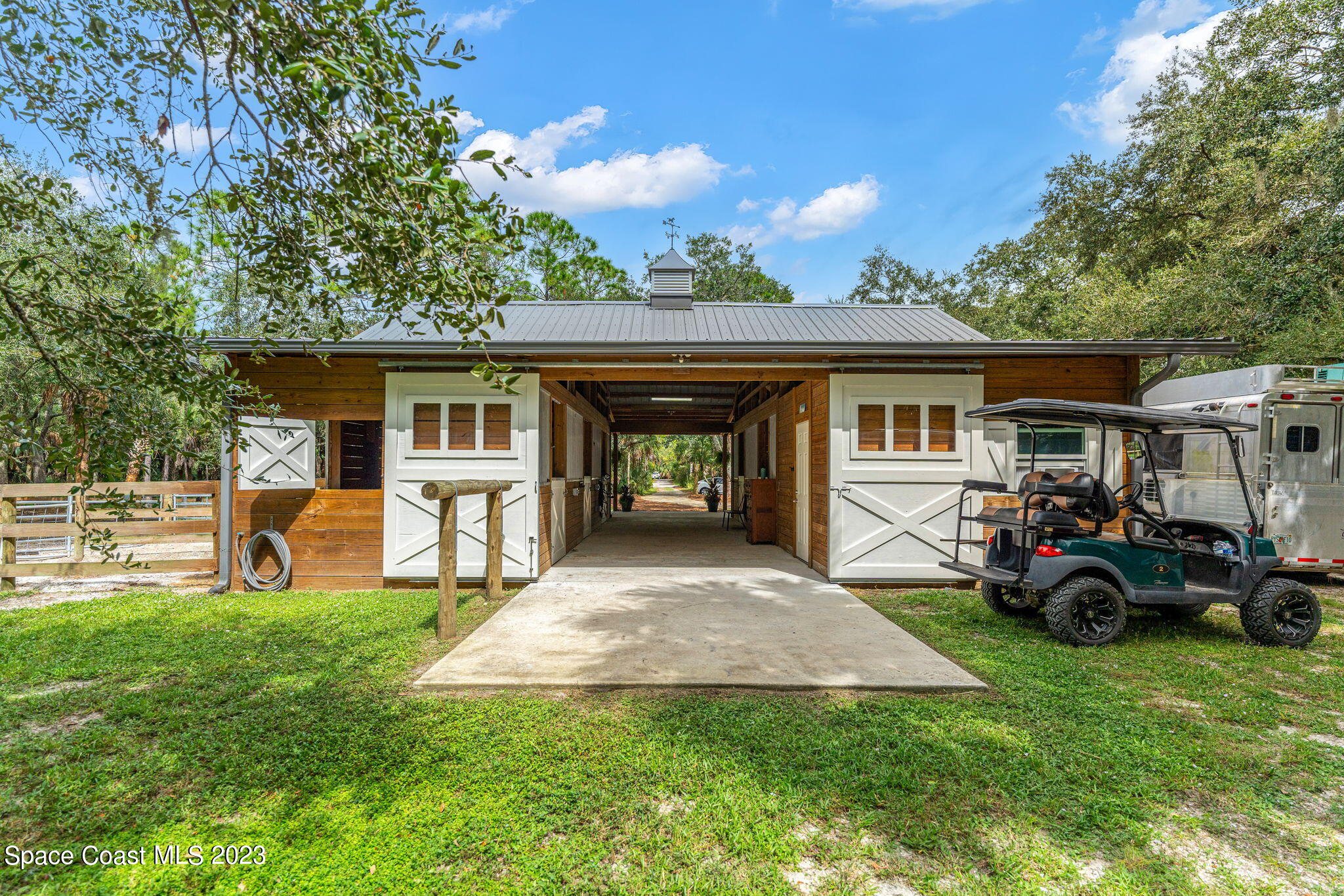5595 Willoughby Drive Melbourne, FL 32934 - Photo 26 of 40 a view of a house with a patio and a car parked in it