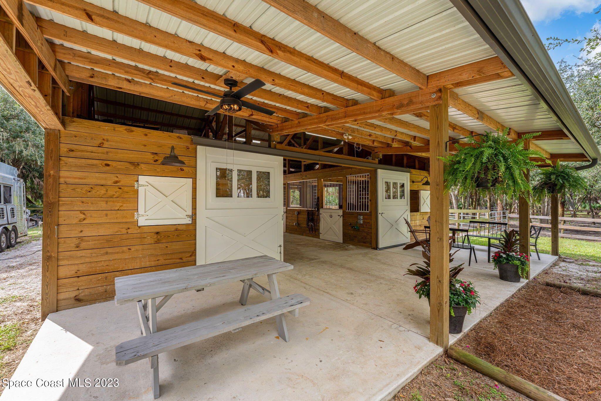 5595 Willoughby Drive Melbourne, FL 32934 - Photo 27 of 40 a view of a patio with table and chairs with wooden floor and fence