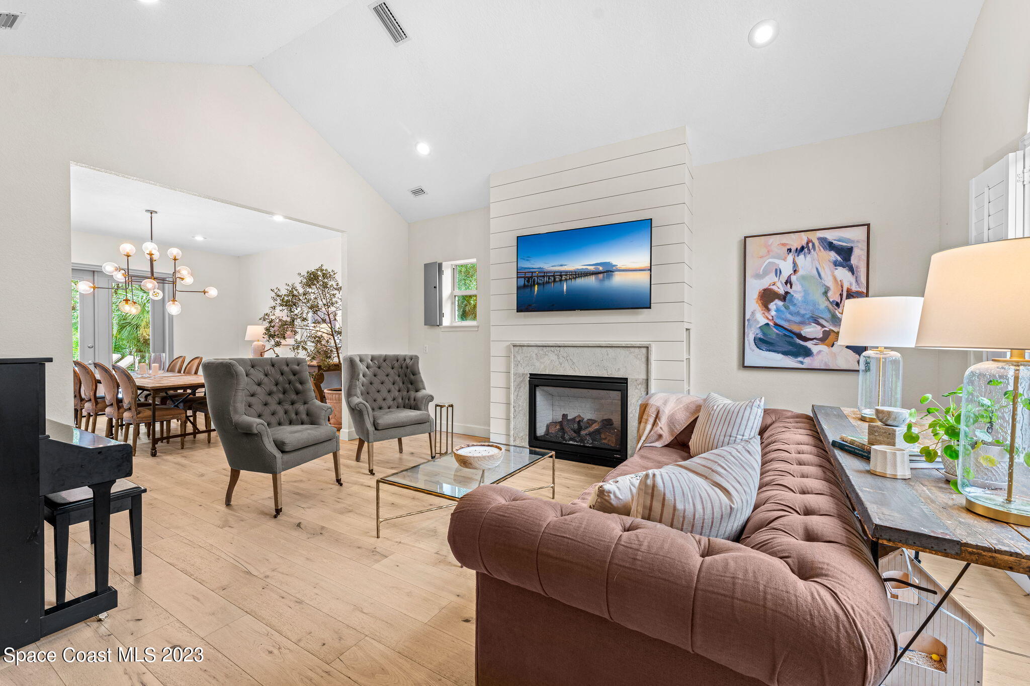 5595 Willoughby Drive Melbourne, FL 32934 - Photo 6 of 40 a living room with furniture a flat screen tv and a fireplace