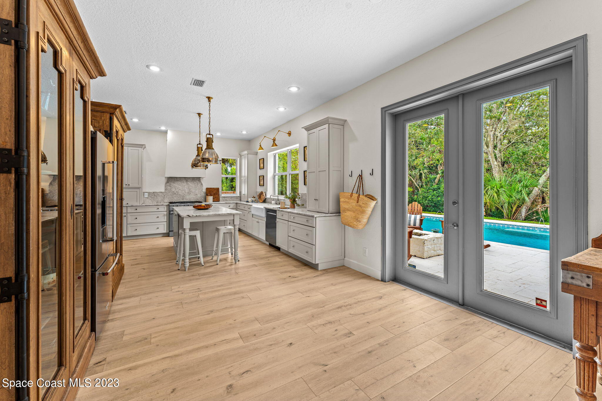 5595 Willoughby Drive Melbourne, FL 32934 - Photo 8 of 40 a room with stainless steel appliances wooden floor and furniture