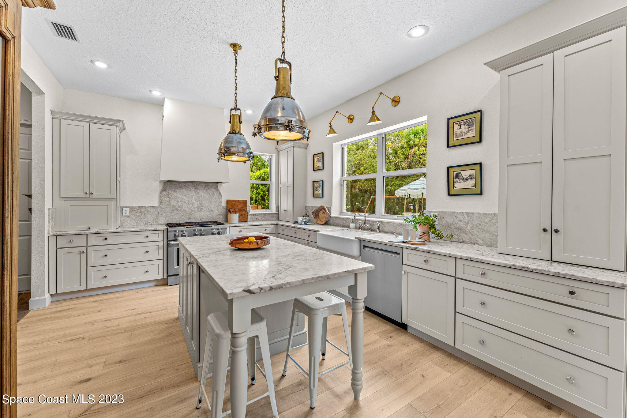 5595 Willoughby Drive Melbourne, FL 32934 - Photo 9 of 40 a kitchen with stainless steel appliances granite countertop stove a sink dishwasher and a refrigerator with wooden floor