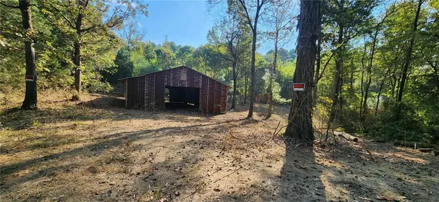 a view of a house with a large tree and a yard
