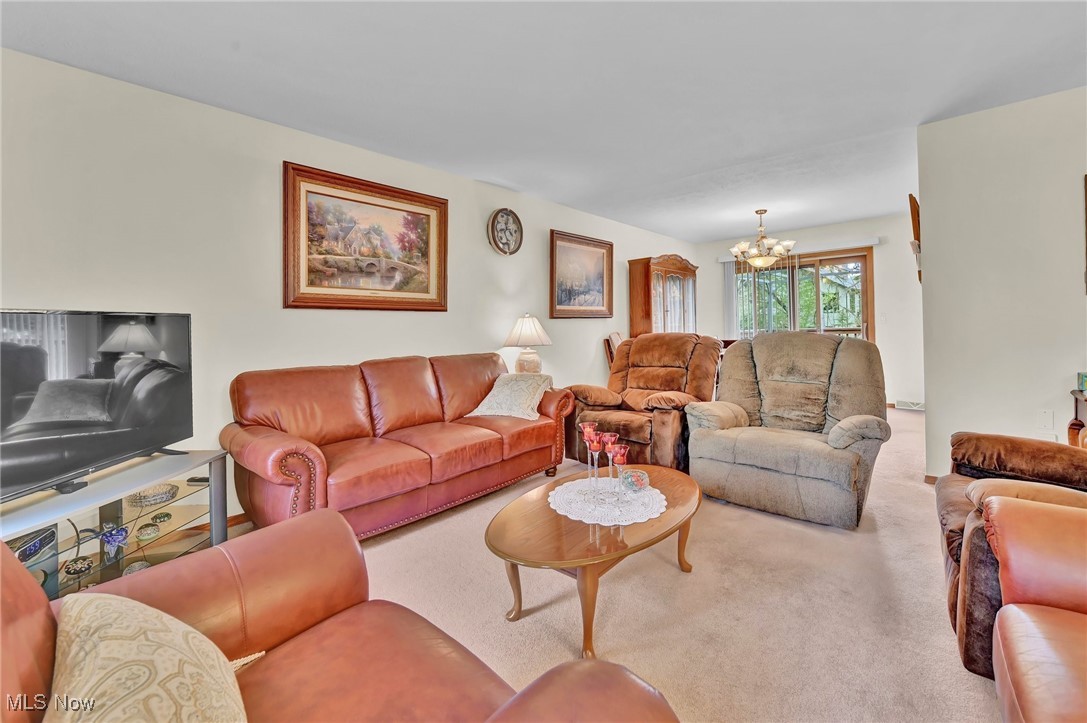 Carpeted living area with an inviting chandelier