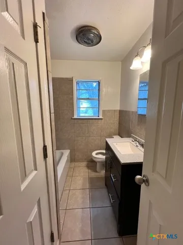 a bathroom with a sink a toilet a mirror and vanity