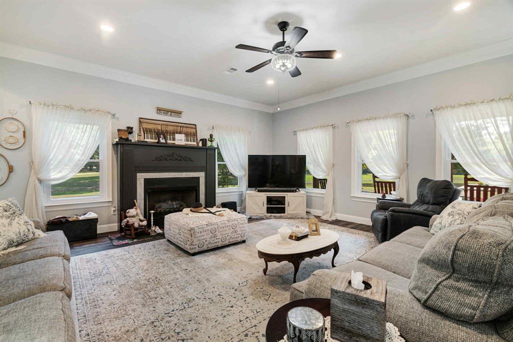2205 County Road Blossom, TX 75416 - Photo 6 of 27 Living area with a fireplace, wood finished floors, plenty of natural light, a ceiling fan, and recessed lighting