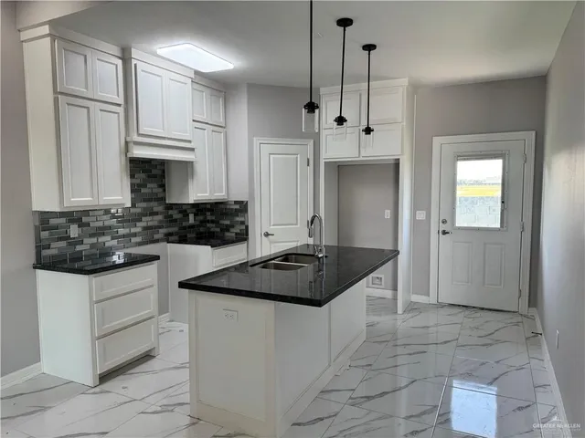a kitchen with granite countertop a sink stainless steel appliances and cabinets