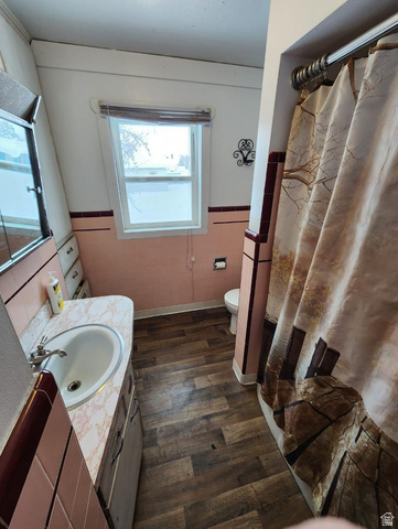 102 South Main Street Paris, ID 83261 - Photo 14 of 33 Full bathroom with vanity, wainscoting, a shower with curtain, tile walls, and dark wood-style flooring
