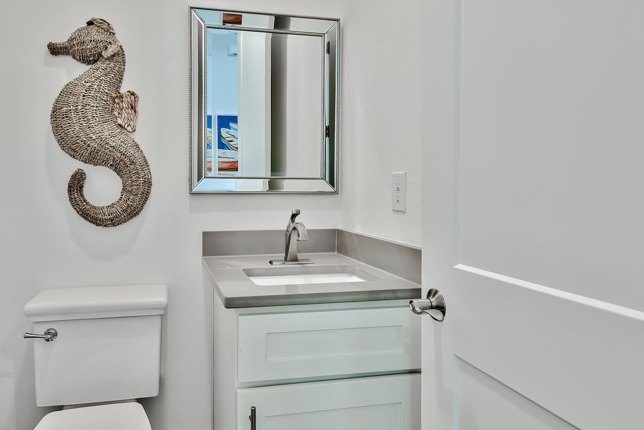 61 Carefree Lane Santa Rosa Beach, FL 32459 - Photo 29 of 30 a bathroom with a toilet a sink and mirror