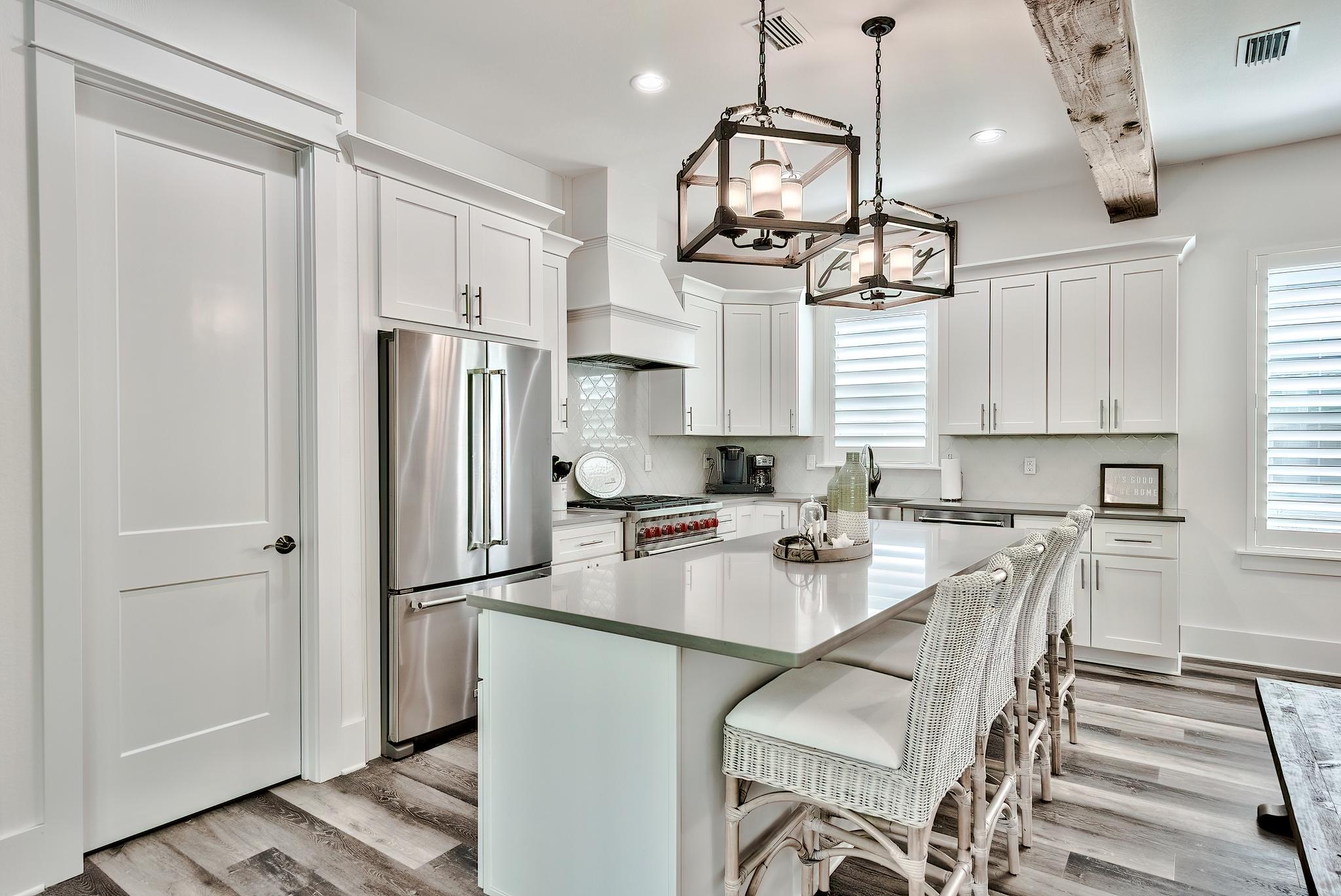 61 Carefree Lane Santa Rosa Beach, FL 32459 - Photo 5 of 30 a kitchen with stainless steel appliances granite countertop a refrigerator a sink dishwasher a stove and white cabinets with wooden floor