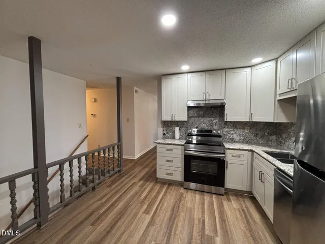 a kitchen with stainless steel appliances granite countertop a stove and a sink