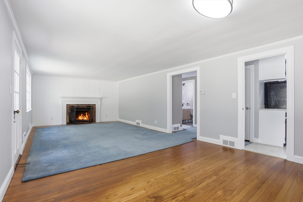 11 Sherman's Bridge Road Wayland, MA 01778 - Photo 14 of 38 an empty room with wooden floor and fireplace