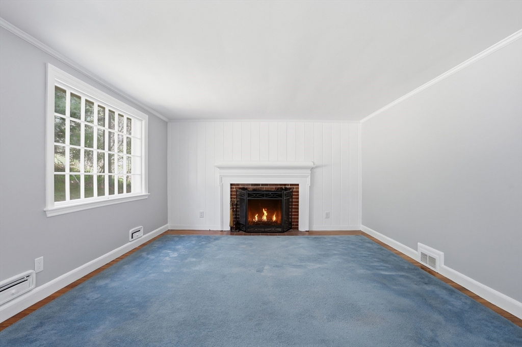11 Sherman's Bridge Road Wayland, MA 01778 - Photo 15 of 38 an empty room with a fireplace and window