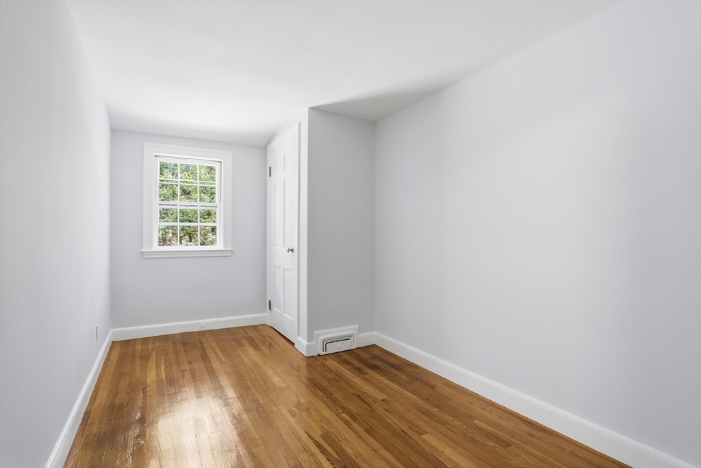11 Sherman's Bridge Road Wayland, MA 01778 - Photo 26 of 38 an empty room with wooden floor and windows