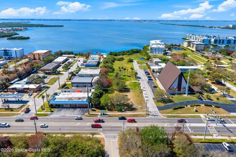 an aerial view of ocean and residential houses with outdoor space