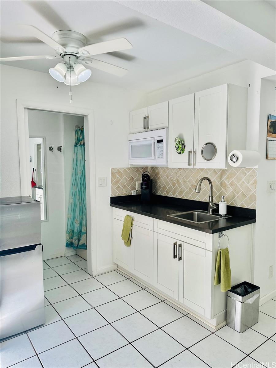 a kitchen with stainless steel appliances a sink a stove and white cabinets