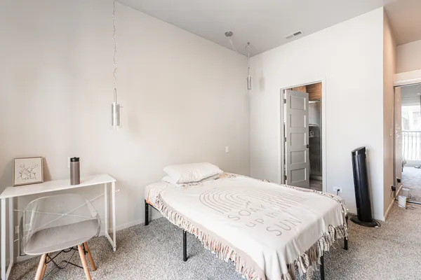 a bedroom with a bed table and chair