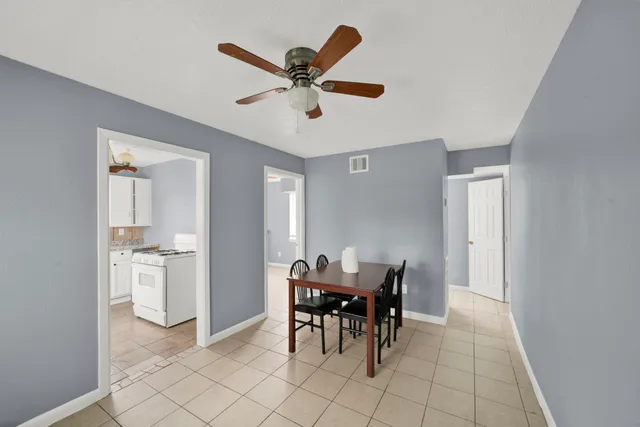 a view of a dining room with furniture and a chandelier fan
