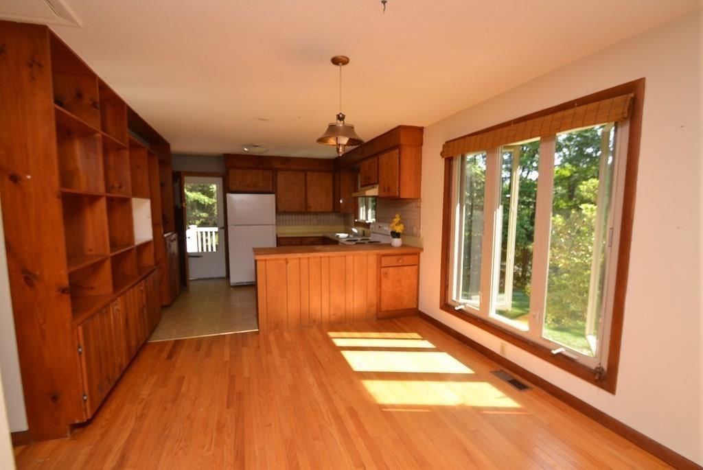 442 Warren Wright Road Belchertown, MA 01007 - Photo 11 of 35 a kitchen with stainless steel appliances granite countertop a refrigerator a sink dishwasher a stove and a dining table with wooden floor