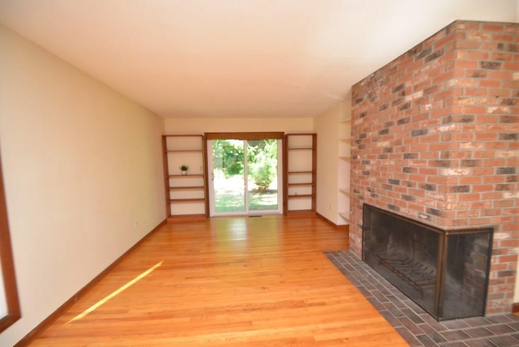 442 Warren Wright Road Belchertown, MA 01007 - Photo 7 of 35 a view of an empty room with wooden floor and a fireplace