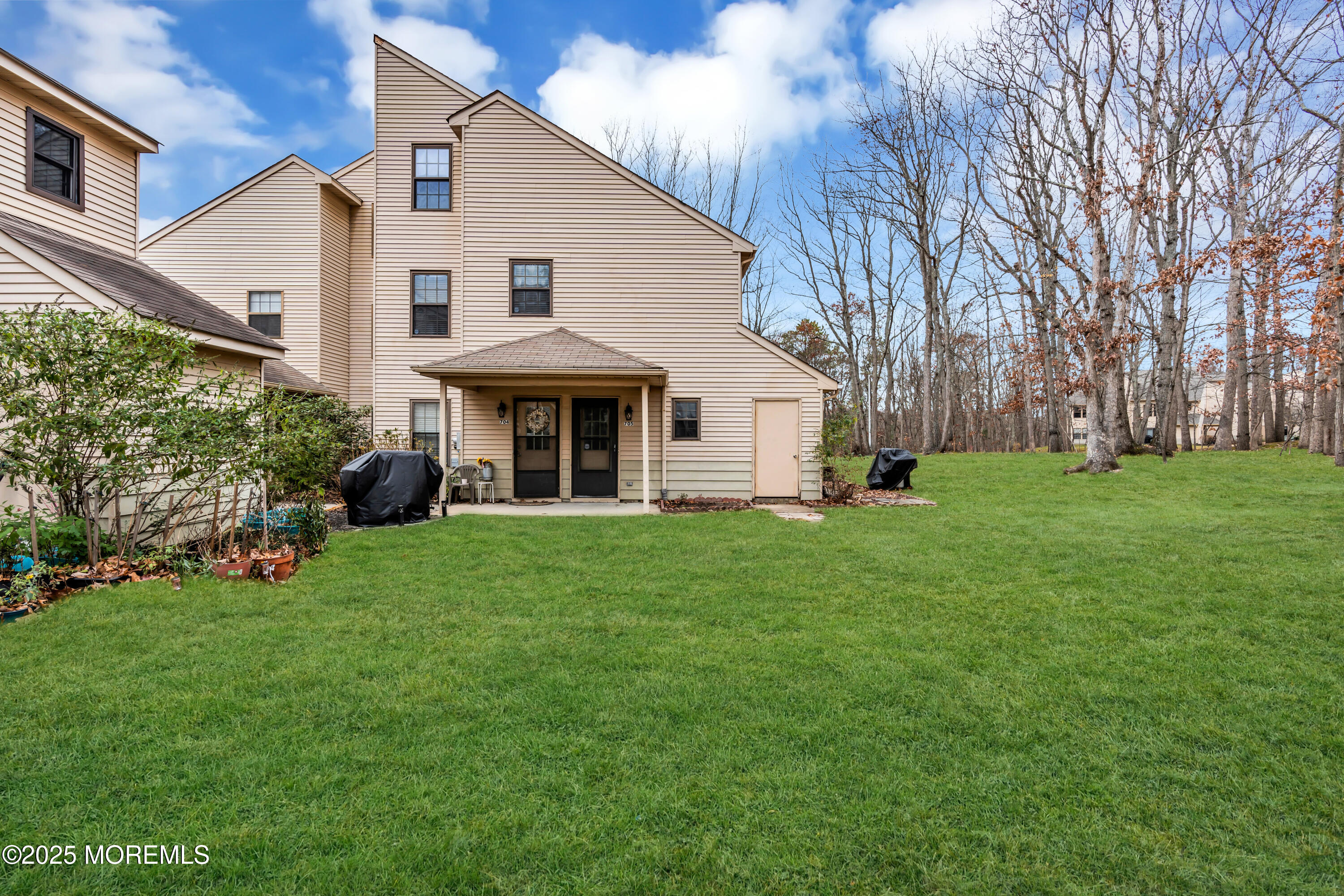 705 Bluebell Drive Jackson, NJ 08527 - Photo 2 of 44 a view of a white house with a big yard potted plants and large tree