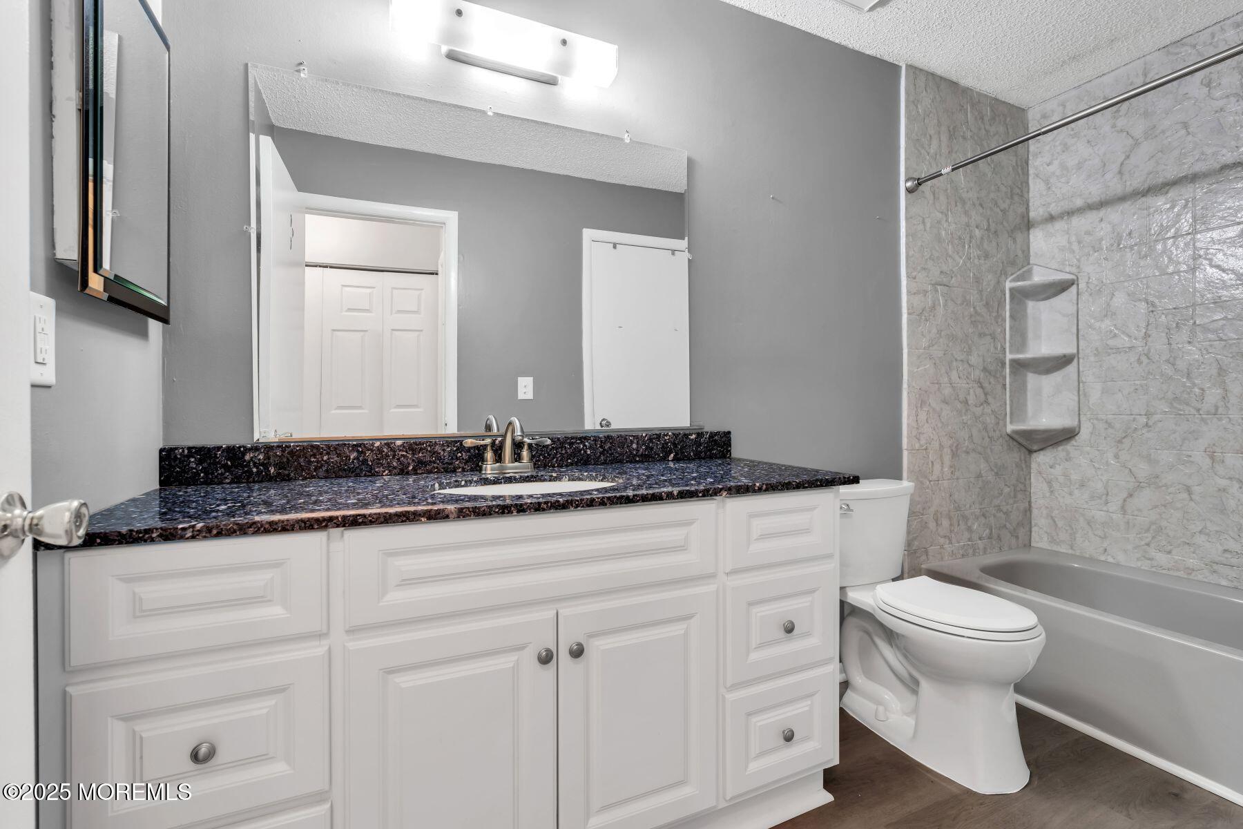 705 Bluebell Drive Jackson, NJ 08527 - Photo 26 of 44 a bathroom with a granite countertop sink a toilet and a mirror