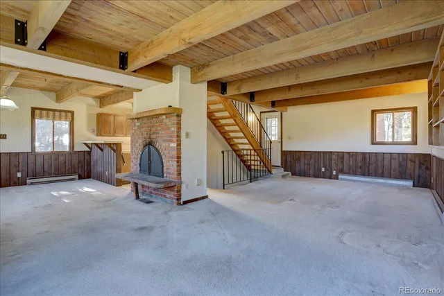 a view of an empty room with wooden floor and windows
