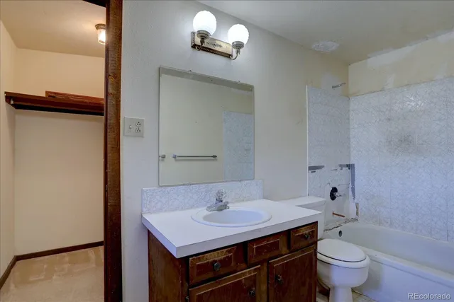 a bathroom with a sink a toilet a mirror and shower
