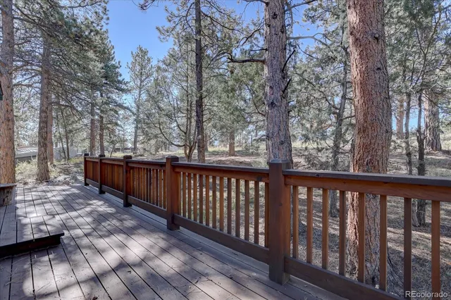 a view of deck with wooden floor and trees