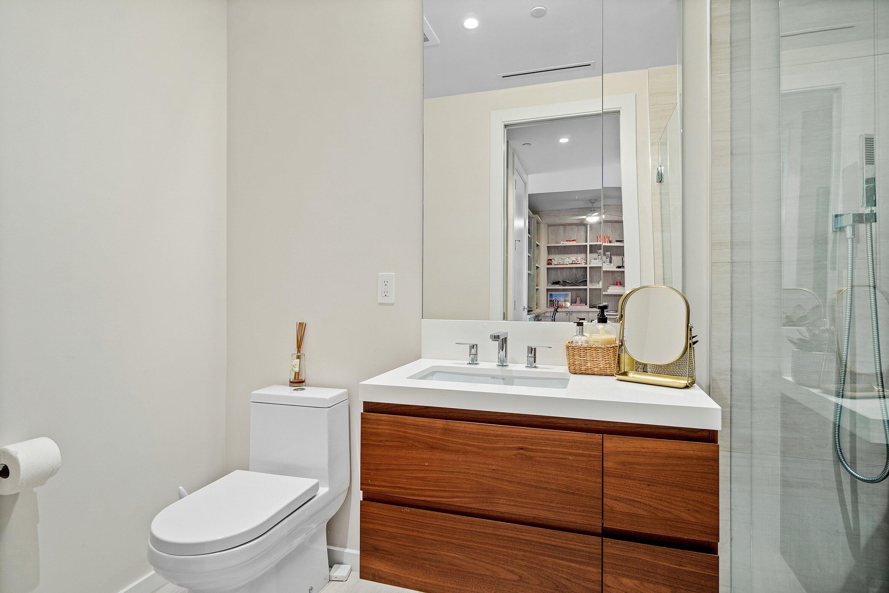 200 Southeast Mizner Boulevard, Unit 810 Boca Raton, FL 33432 - Photo 21 of 29 a bathroom with a granite countertop toilet sink and mirror