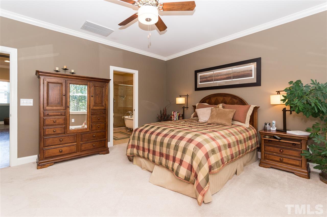 2711 Bembridge Drive Raleigh, NC 27613 - Photo 14 of 25 a bedroom with a large bed and a chandelier