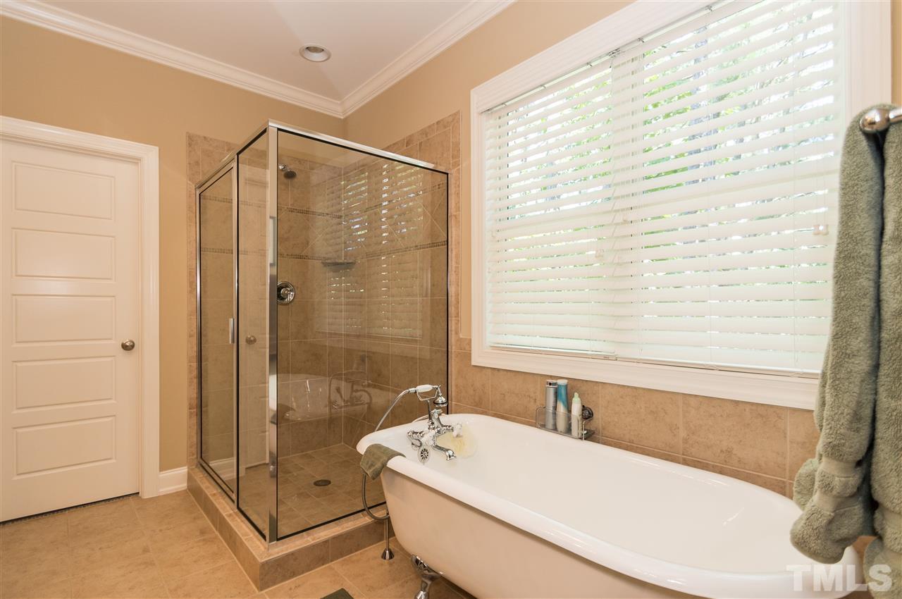 2711 Bembridge Drive Raleigh, NC 27613 - Photo 16 of 25 a bathroom with a tub a sink and a shower