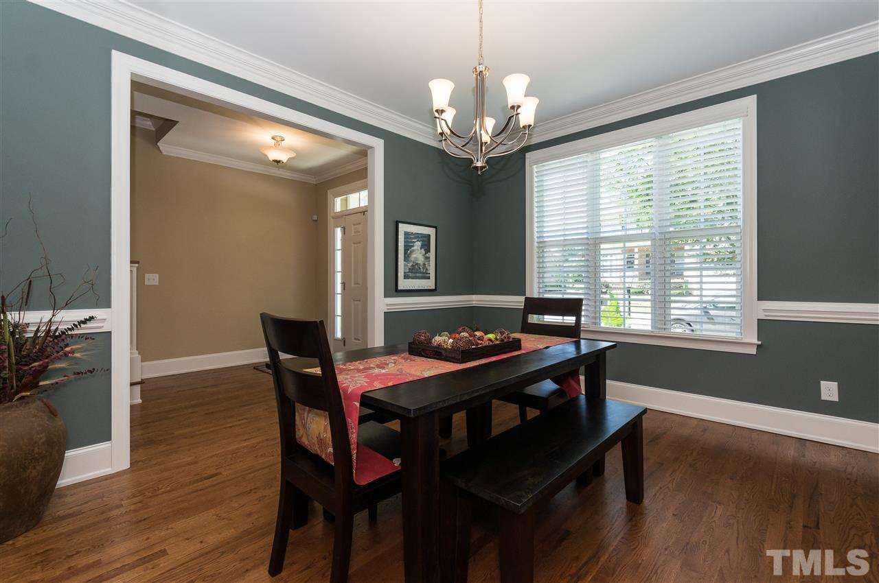 2711 Bembridge Drive Raleigh, NC 27613 - Photo 4 of 25 a dining room with wooden floor a chandelier a wooden table and chairs