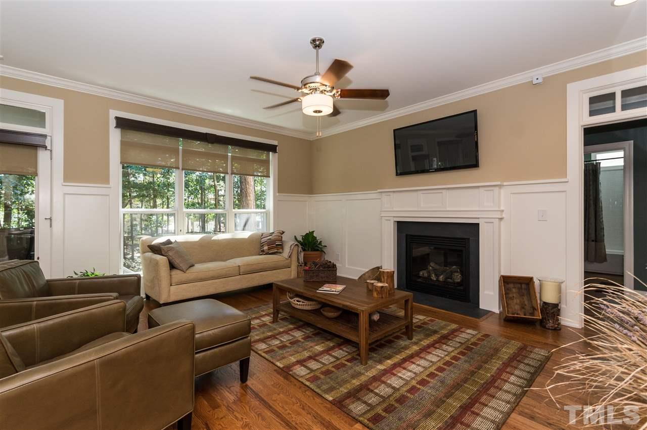 2711 Bembridge Drive Raleigh, NC 27613 - Photo 5 of 25 a living room with furniture a flat screen tv and a fireplace