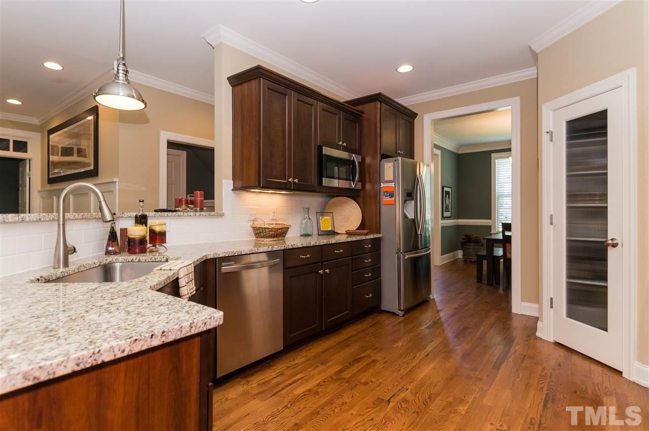 2711 Bembridge Drive Raleigh, NC 27613 - Photo 7 of 25 a kitchen with stainless steel appliances granite countertop a sink refrigerator and cabinets