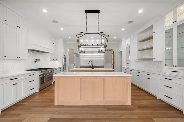 a kitchen with stainless steel appliances granite countertop a stove oven and a white cabinets