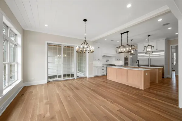 a large kitchen with granite countertop a large counter top a sink stainless steel appliances and cabinets