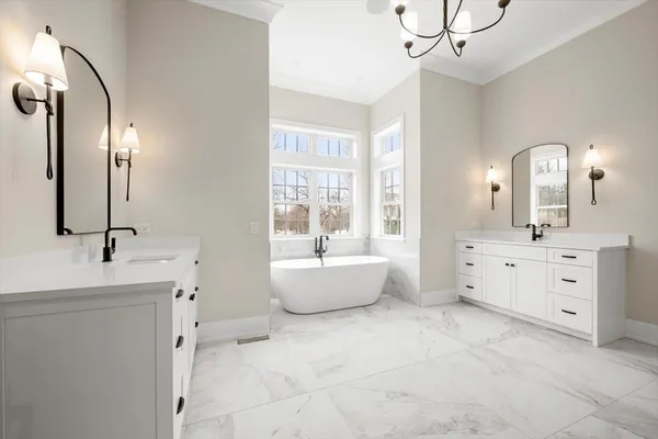 a spacious bathroom with a double vanity sink mirror and bathtub