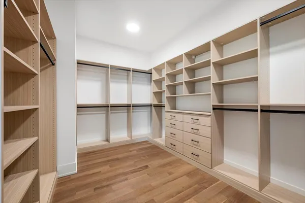a view of walk in closet with empty racks