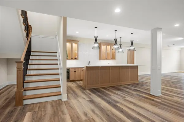 a large white kitchen with kitchen island a sink stainless steel appliances and cabinets