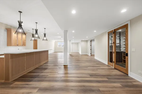 a view of large kitchen with kitchen island a sink wooden floor and glass doors