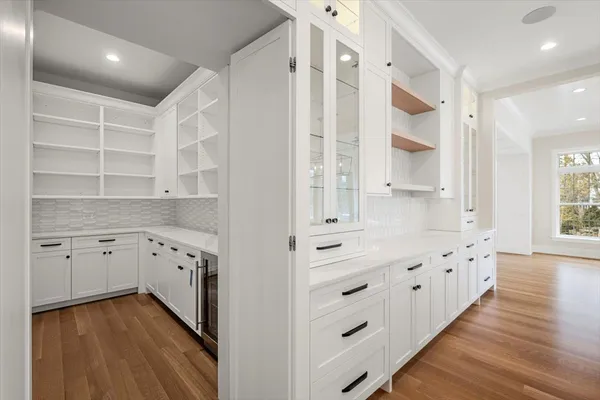 a kitchen with granite countertop white cabinets and wooden floor