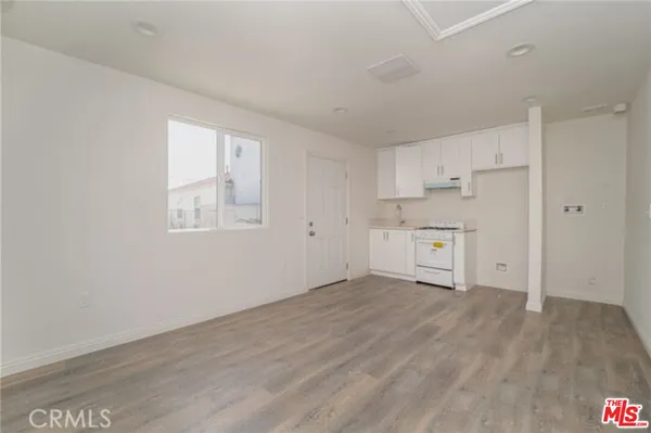 a view of a kitchen with wooden floor and a window