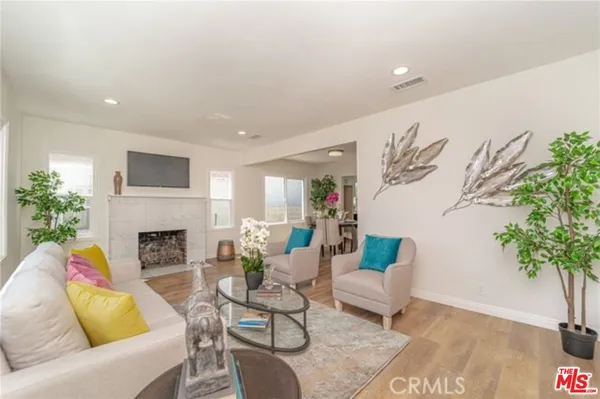 a living room with furniture fireplace and potted plant