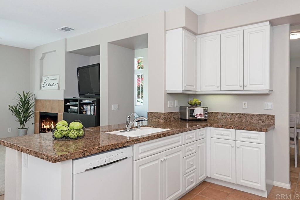 5595 Foxtail Loop Carlsbad, CA 92010 - Photo 11 of 28 a kitchen with granite countertop a sink and white cabinets