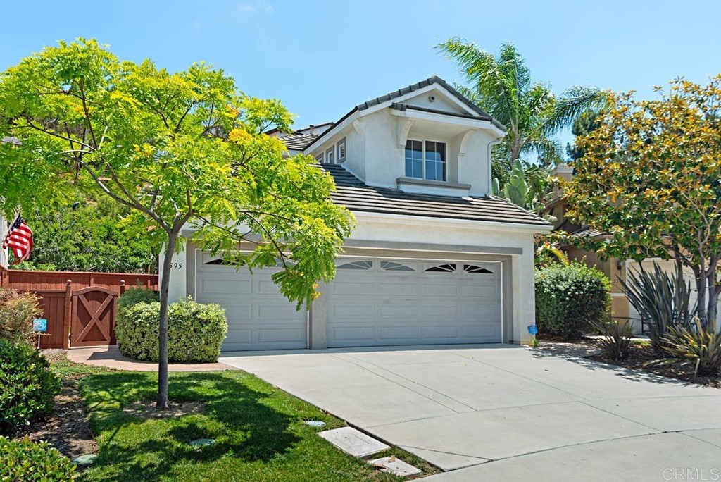 5595 Foxtail Loop Carlsbad, CA 92010 - Photo 2 of 28 a front view of a house with a yard and a garage