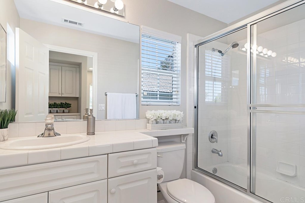 5595 Foxtail Loop Carlsbad, CA 92010 - Photo 22 of 28 a bathroom with a shower sink vanity mirror and toilet