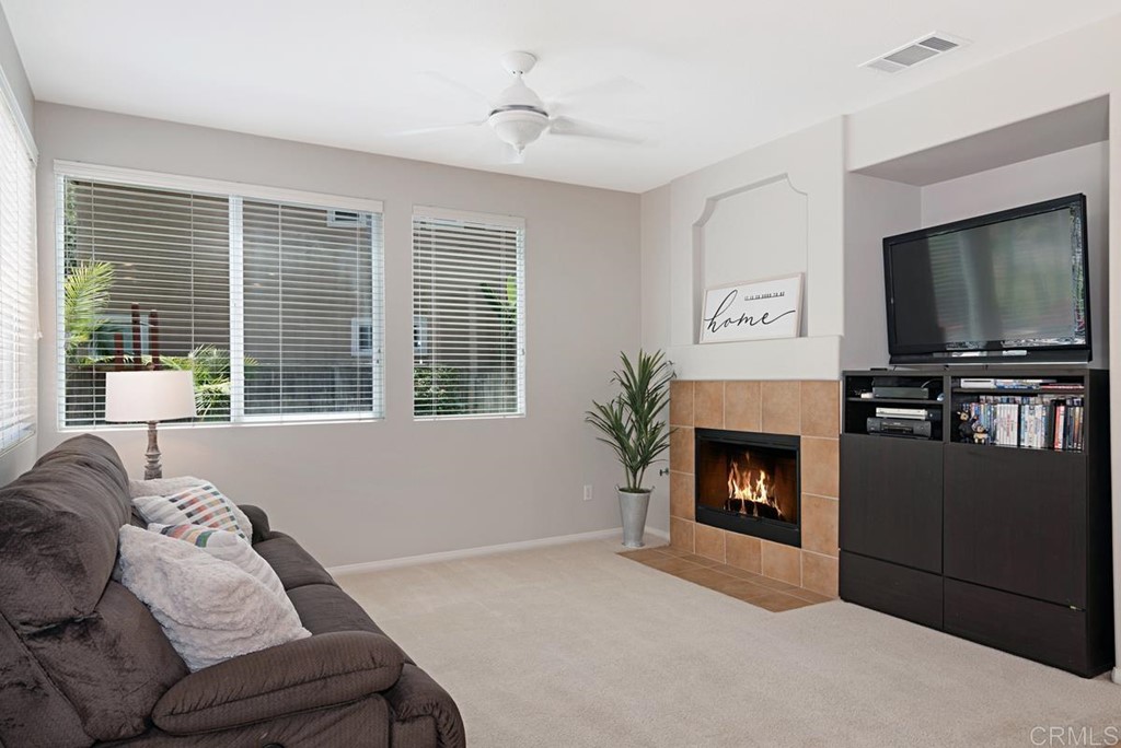 5595 Foxtail Loop Carlsbad, CA 92010 - Photo 7 of 28 a living room with furniture a flat screen tv and a fireplace