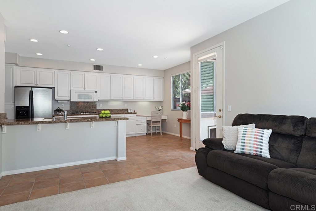 5595 Foxtail Loop Carlsbad, CA 92010 - Photo 8 of 28 a living room with furniture and kitchen view